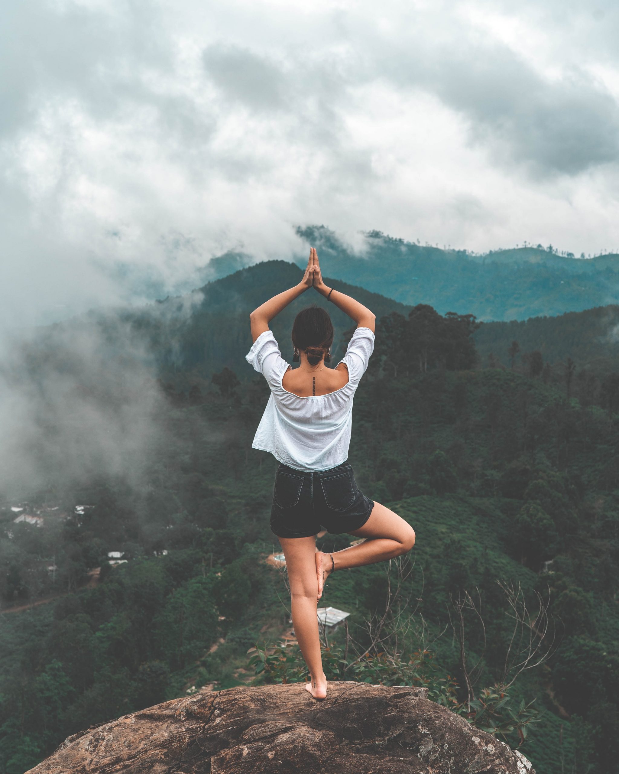 Woman in a yoga pose on a mountain